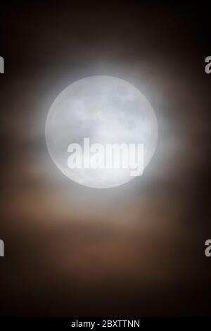 Vollmond mit Erdbeere durch Wolken über den Rocky Mountains, Salida, Colorado, USA Stockfoto