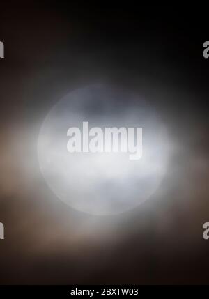 Vollmond mit Erdbeere durch Wolken über den Rocky Mountains, Salida, Colorado, USA Stockfoto