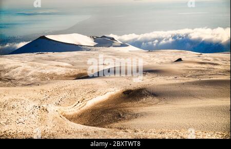 Cratere del vulcano Etna nel paesaggio innevato con nuvole e il golfo di Catania da sfondo Stockfoto