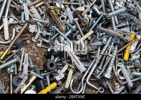 Viele verschiedene Befestigungsschrauben und Muttern flach legen. Metallwerkzeuge Nahaufnahme. Abstrakter industrieller Hintergrund für Vatertag Stockfoto