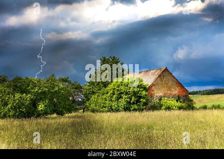 Alte Scheune. Gewitterwolken über der Landschaft. Landwirtschaftliche Landschaft in der Tschechischen Republik. Starker Sturm. Stockfoto