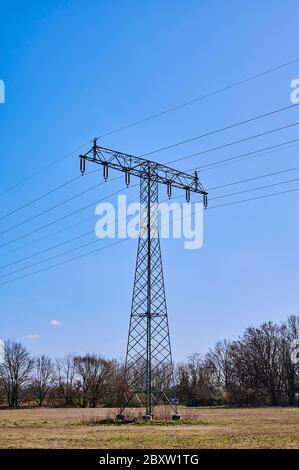 Stromast auf einer Wiese in Deutschland vor blauem Himmel. Stockfoto