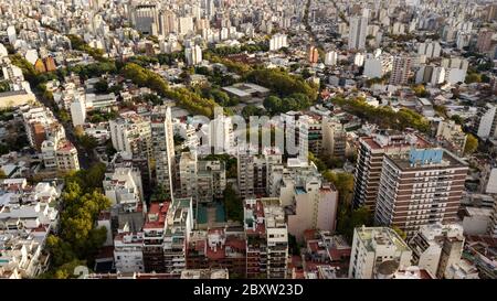 Luftaufnahme des Palermo-Viertels in Buenos Aires während des Sonnenuntergangs mit Blick auf Gebäude, Parks, Herbstbäume, Wohnungen und Dächer. Stockfoto