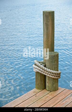 Die Ecke eines Bootsanlegs, auf einem See, mit Seil umwickelt Pilings. Stockfoto