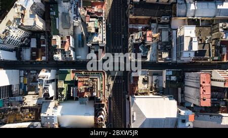 Luftaufnahme von oben auf vier-Wege-Kreuzung zwischen hohen Gebäuden während Sonnenuntergang ohne Menschen oder Verkehr aufgrund der Quarantäne 2020 Stockfoto