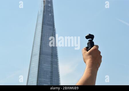 London, Großbritannien - August 2019: Männliche Hand hält eine DJI Osmo Pocket Gimbal Kamera vor dem berühmten britischen Wahrzeichen Stockfoto