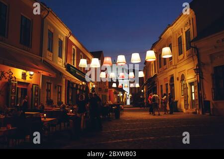 SZENTENDRE, UNGARN - 23. Juli 2019 - Nachtsicht auf das kunstvoll beleuchtete Stadtzentrum von Szentendre, ungarische Stadt voller Kunst- und Souvenirläden Stockfoto