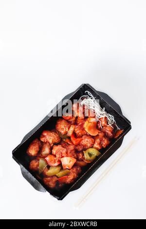 Hähnchenstücke mit roter Paprika in saurer-süßer Sauce, verzehrfertige traditionelle chinesische Küche, Menü mit Lieferservice Stockfoto