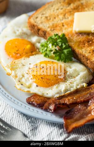 Hausgemachte Sunnyside Eier Frühstück mit Toast und Speck Stockfoto