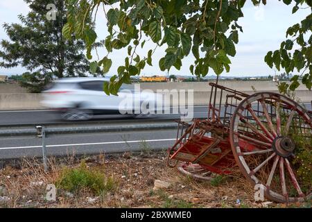 Ein Auto mit voller Geschwindigkeit fährt vor einem alten Pferdewagen Stockfoto