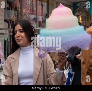 Ein Besucher der Takeshita Straße genießt eine riesige bunte Zuckerwatte auf Bestellung Stockfoto