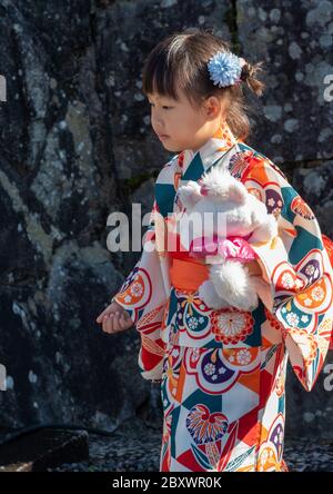 Ein kleines japanisches Mädchen in traditioneller Kleidung und Kimono am Kiyomizu Dera-Schrein in Kyoto, Japan. Stockfoto