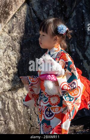 Ein kleines japanisches Mädchen in traditioneller Kleidung und Kimono am Kiyomizu Dera-Schrein in Kyoto, Japan. Stockfoto