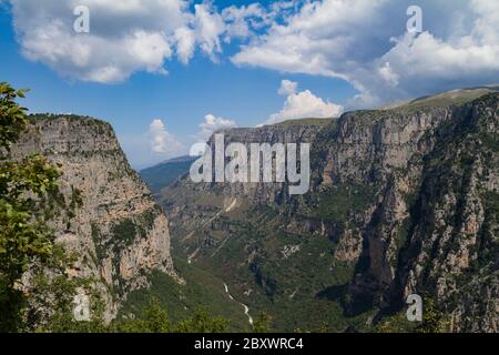 Vikos-Schlucht, Epirus, Griechenland. Ein atemberaubender Blick auf die Schlucht von Oxia, im Sommer. Der Fluss Voidomatis fließt in die Schlucht. Der Himmel ist teilweise wolkenverhängt Stockfoto