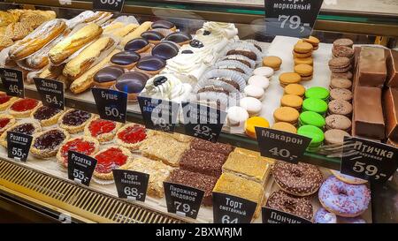 Moskau, Russland, 17. Mai 2020. Kuchen auf den Regalen eines Fensters eines Straßenrestaurants. Schaufenster einer Konditorei oder Café mit vielen Süßigkeiten und Preis Stockfoto