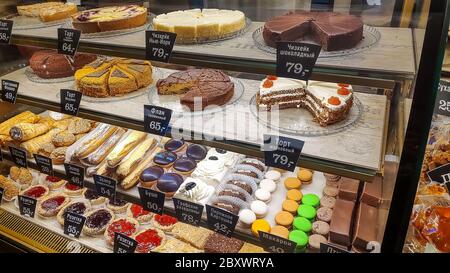 Moskau, Russland, 17. Mai 2020. Kuchen auf den Regalen eines Fensters eines Straßenrestaurants. Schaufenster einer Konditorei oder Café mit vielen Süßigkeiten und Preis Stockfoto