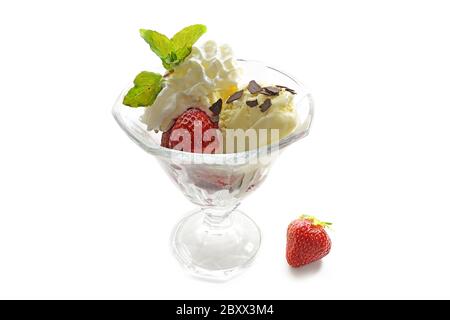 Eiscreme, frische Erdbeeren, Schlagsahne und Pfefferminze garnieren in einem Glaspelz, isoliert mit Schatten auf weißem Hintergrund Stockfoto