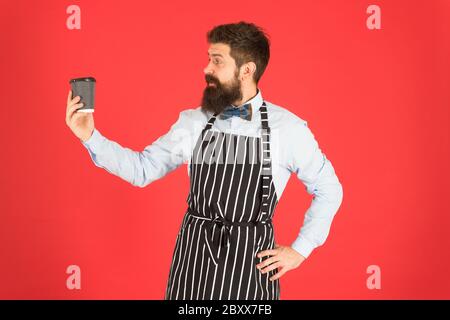 Brutale Kaffeemaschine. Porträt von bärtigen Barista stehen im Café. Barista gutaussehende Arbeiter. Freundliche Barista geben große Latte. Professionelle Kellner oder Barkeeper servieren Kaffee. Stockfoto