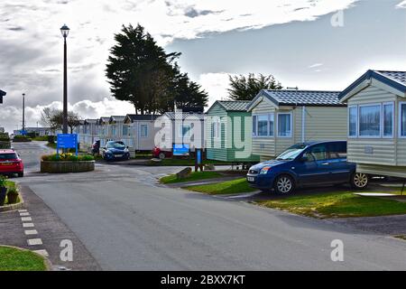 Autos vor Ferienhäusern geparkt. Die statischen Wohnwagen sind Teil des Trecco Bay Site, - einem Parkdean Resort in Porthcawl, S.Wales Stockfoto