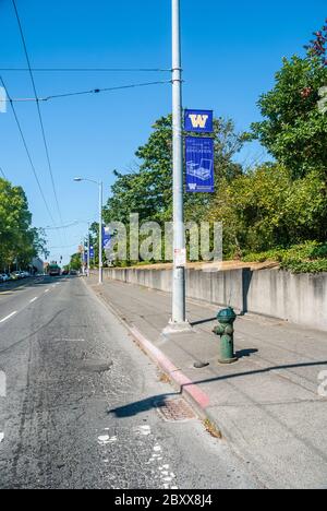 Banner der Universität von Washington auf einer Straße im Universitätsviertel im Bundesstaat Washington. Die Straße ist renovierungsbedürftig. Stockfoto