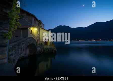 Landschaftlich reizvolle Aufnahme von Nesso am Comer See in Italien mit Steinvordergrund zur blauen Stunde Stockfoto