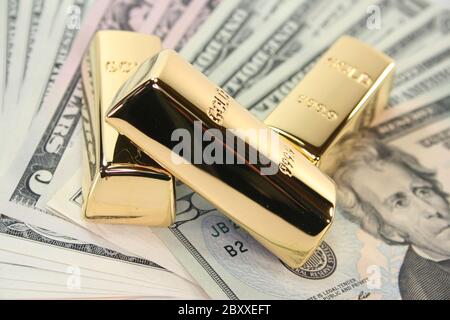 Goldbarren mit Dollarnoten Stockfoto