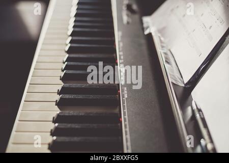 Nahaufnahme Vintage-Aufnahme von 88 elfenbeinfarbenen Tasten-Tastatur und Noten in einem Haus Stockfoto