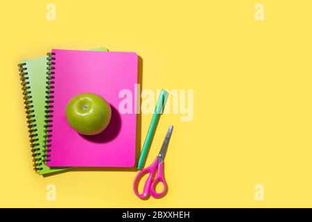Helle Schulbedarf, Notizbücher auf gelbem Hintergrund. Draufsicht, flaches Lay. Kopierbereich. Stockfoto