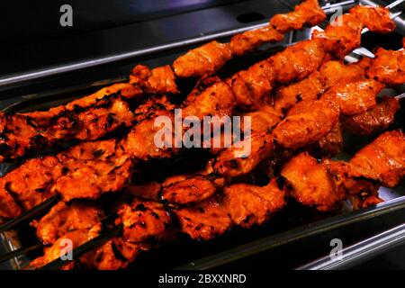 Gewürz marinierten Hühnerwürfel ( Huhn tikka ) Spieße Kochen in einem Tonofen bekannt als Tandoor Stockfoto