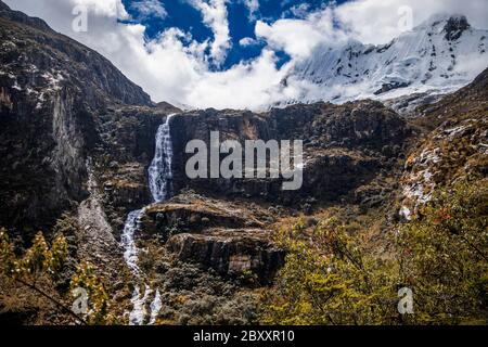 Wasserfall in Bergen, Bäumen, Wolken und blauem Himmel Stockfoto