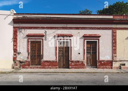 Fassade eines typischen mexikanischen verlassenen Kolonialgebäudes mit Holztüren in Merida, Yucatan, Mexiko Stockfoto