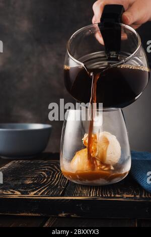 Einen Kaffee mit Vanilleeis in ein Glas gießen Stockfoto