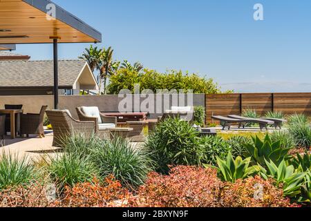 Schönes Strandhaus mit schön angelegten Garten vor dem Hof, mit tropischen Pflanzen und Gartenmöbeln Stockfoto