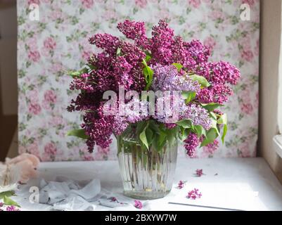 Bouquet von violettem Flieder in einer Vase. Stillleben mit blühenden Fliederzweigen in Vasen. Kostenloses Foto. Stockfoto