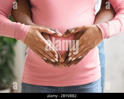 Hände von Frau und Mann auf dem Bauch der schwangeren Frau Stockfoto