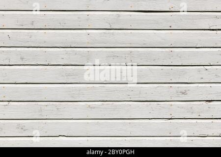 Weiße Holzwand mit reicher Textur, Rissen, Knoten und Nägeln. Verwitterte Holzplanken Hintergrund. Stockfoto