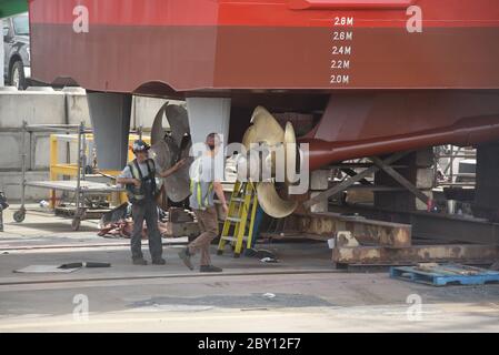 Zwei Arbeiter schauen auf die Propeller des kanadischen Küstenwache-Helden-Klasse-Schiffes, CCGS Private Robertson V.C., im Trockendock, um die Wartung an der POI zu machen Stockfoto