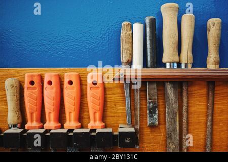 Die Werkzeuge des Zimmermanns hängen ordentlich an der Wand. Arbeitsauftrag. Rashpil, Feile und Meißel Nahaufnahme. Kopierbereich Stockfoto