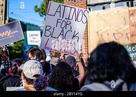 SEATTLE, USA - 6. JUNI 2020: Eine lateinerin hält ein Schild in einer Demonstration gegen Rassismus in der Nähe eines Polizeibezirks von Seattle Stockfoto