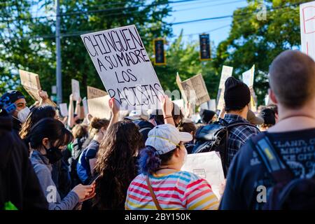 SEATTLE, USA - 6. JUNI 2020: Eine lateinerin hält ein Schild in einer Demonstration gegen Rassismus in der Nähe eines Polizeibezirks von Seattle Stockfoto