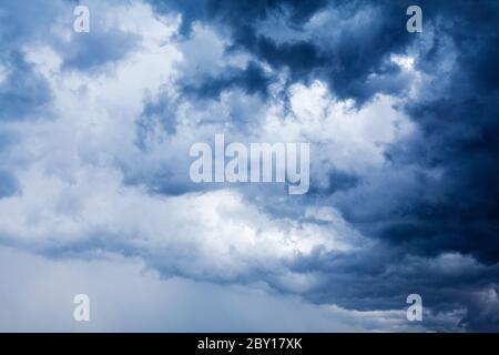 Stürmisch bewölktes Himmel Nahaufnahme, dunkelblaue Gewitterwolken, weiße Cumuluswolken, regnerische Gewitterlandschaft, trübes Schlechtwetter, trübes Panorama Stockfoto