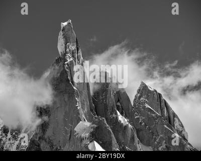 Monochrom von schneebedeckten Berggipfeln und Wolken gegen klaren Himmel, mt. cerro torre und seine Nachbarn mt. torre egger und punta herron in los glaci Stockfoto