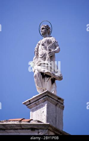 Statue des Heiligen Hieronymus auf dem Dach der Kirche San Sebastiano, die Mitte des 16. Jahrhunderts in Venedig, Italien, erbaut wurde. Stockfoto