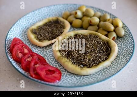 Nahaufnahme von Manaqish b'il Za'atar, einem beliebten leventinischen Gericht, das allgemein der arabischen Küche zugeschrieben wird. Stockfoto