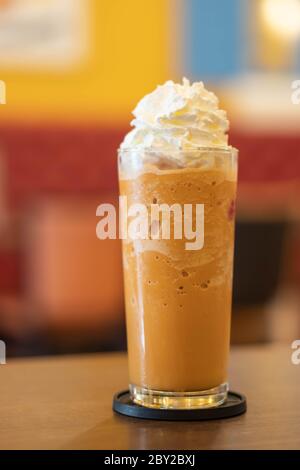 Kaffee Karamell Frappe mit Schlagsahne auf Holztisch Stockfoto