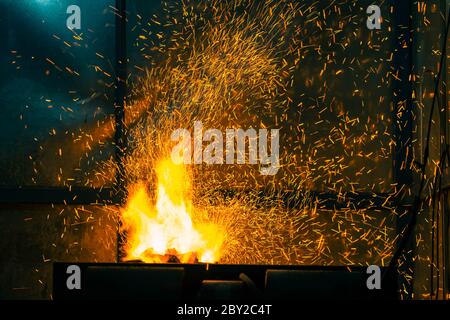 Flamme und Feuerfunke mit Bokeh aus brennender Kohle auf dunklem abstraktem Hintergrund Stockfoto