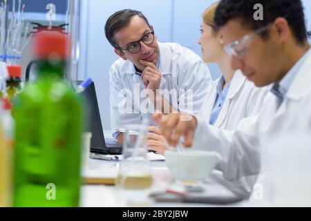 Lehrer im Gespräch mit Studenten in einer naturwissenschaftlichen Klasse Stockfoto