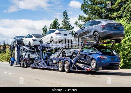 Jun 6, 2020 / CA / USA - Autotransporter führt neue Tesla Model Y (auf der oberen Ebene) und Tesla Model 3 (auf der unteren Ebene) Fahrzeuge auf einer Autobahn i Stockfoto