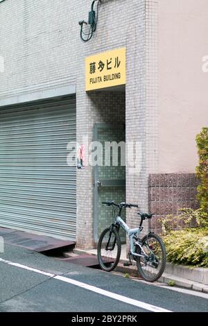 Fahrradparkplatz vor einem Gebäude mit Garage in Japan Stockfoto