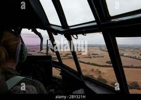 Der Pilot an der Nase, der eine Royal Australian Air Force Lockheed C-130 Hercules fliegt, um müde Feuerwehrleute von Kangaroo Island zurückzuholen. Stockfoto